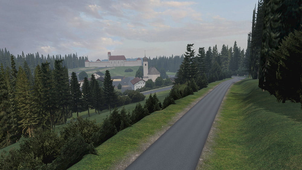A quiet countryside road lined with dense evergreen trees, leading towards a distant village nestled in a valley. The village features a church and several traditional buildings, with rolling hills and a cloudy sky enhancing the peaceful rural setting.
